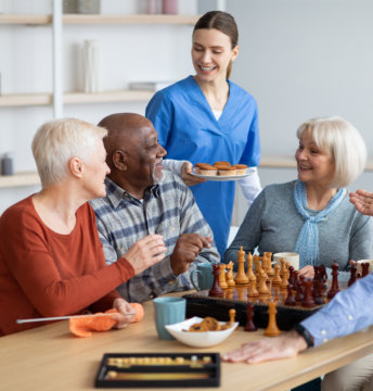 nurse holding plate with cupcakes giving it to the elderly people