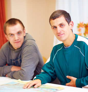 Men sitting and smiling while looking at the camera