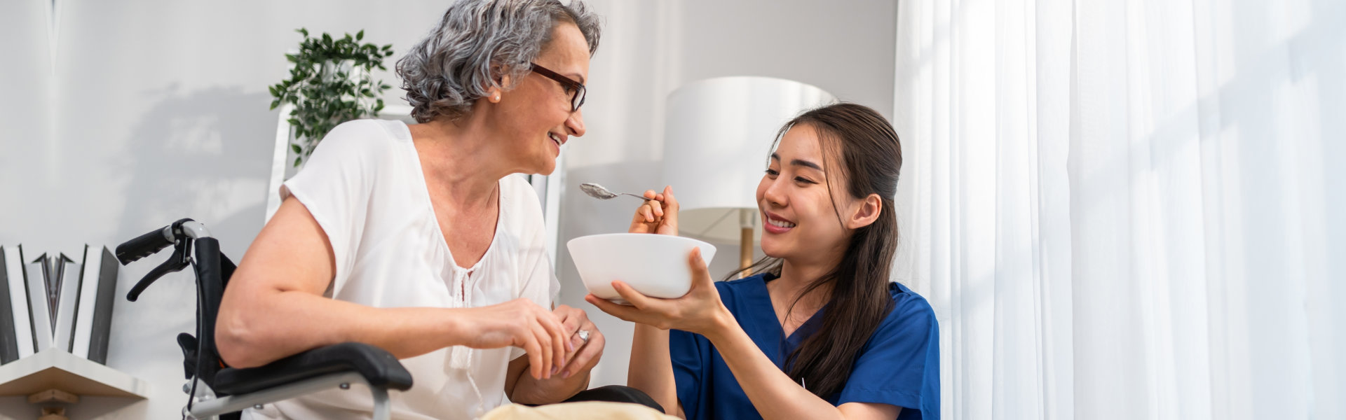 aide feeding senior patient