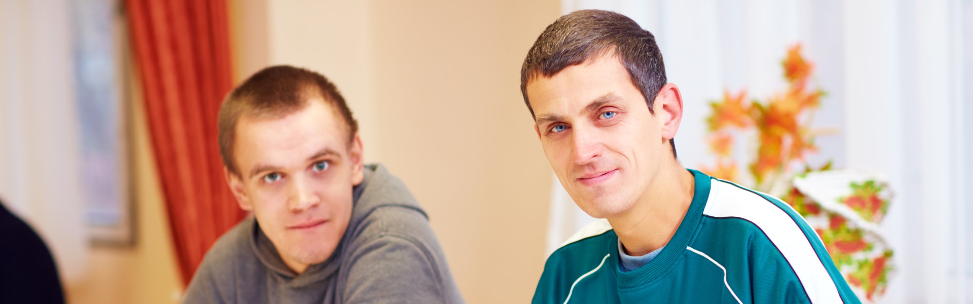 Men sitting and smiling while looking at the camera